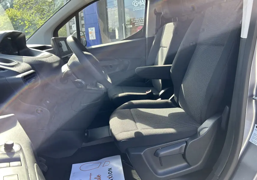 Vue intérieure côté conducteur du DANGEL Partner gris Artense, mettant en valeur les sièges tissu et le tableau de bord simple.