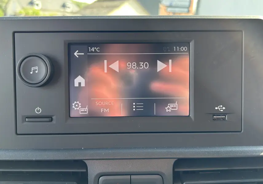 Vue rapprochée de l’écran multimédia central du DANGEL Partner 4x4, avec interface FM et port USB visible.