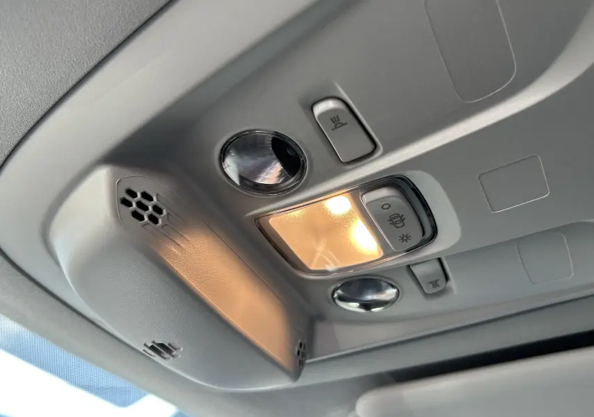 Plafonnier intérieur allumé avec commandes de lumière et micro dans un Peugeot Partner Dangel gris Artense.