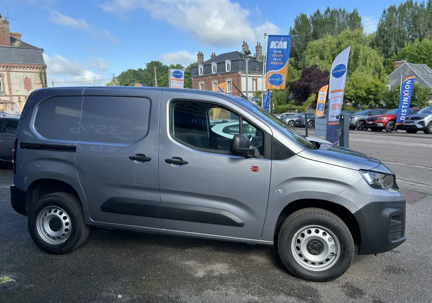Vue de profil côté droit du Peugeot Partner Dangel 4x4 gris Artense avec roues acier et logo Dangel rouge sur porte avant.