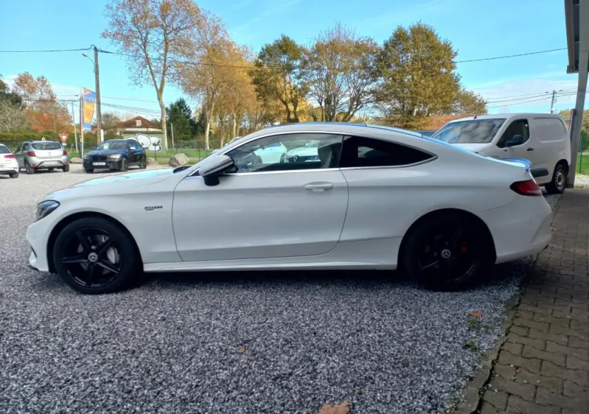 Vue de profil côté gauche d'une Mercedes Classe C Coupé blanche avec jantes noires et lignes épurées.