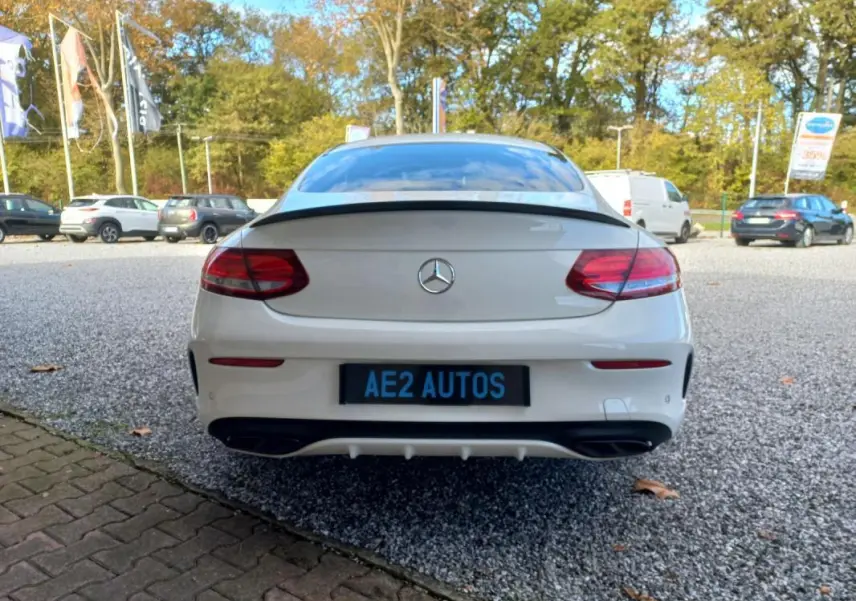 Vue arrière d'une Mercedes Classe C Coupé IV 400 Fascination blanche, avec feux LED et double sortie d'échappement noire.