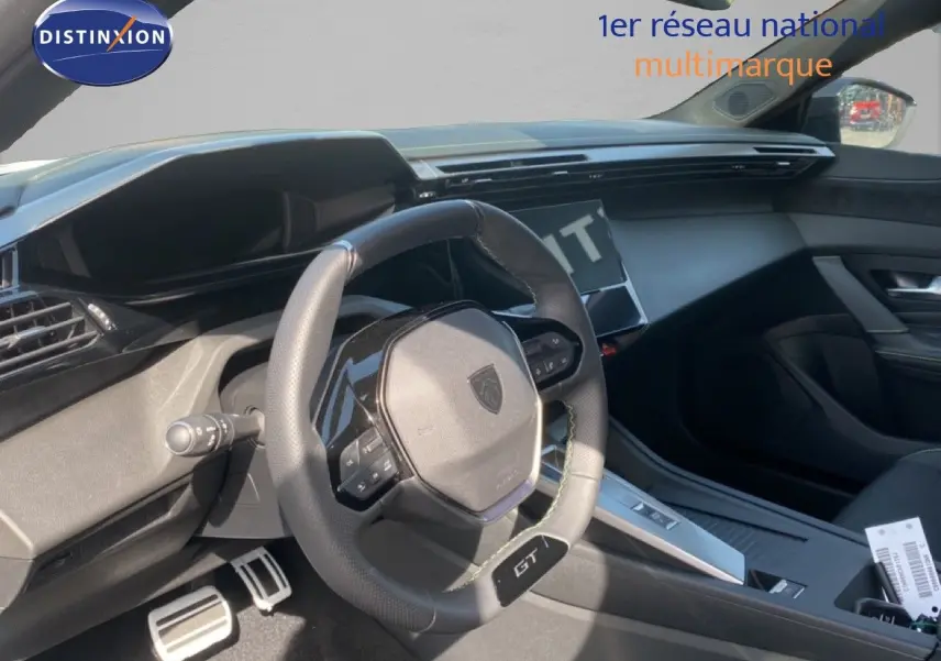 Intérieur de la Peugeot 308 Hybrid 145ch GT 2026 vu côté conducteur, volant cuir GT et tableau de bord moderne noir.