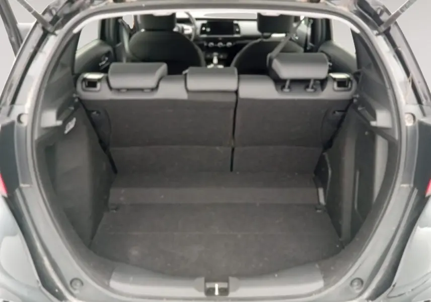 Vue arrière du coffre ouvert de la Honda Jazz 2024 noire, montrant l'espace de chargement et les sièges arrière rabattus.