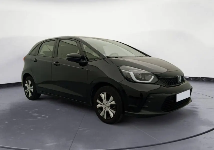 Honda Jazz 2024 noir vue 3/4 avant droit, avec phares LED et jantes spécifiques version hybride essence.