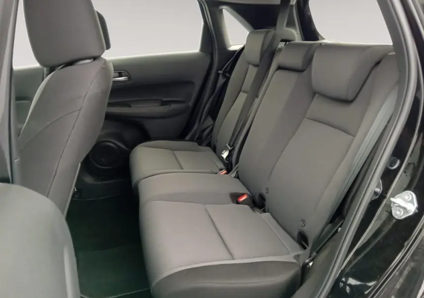 Vue intérieure côté droit des sièges arrière noirs de la Honda Jazz E:HEV 1.5 i-MMD Advance 2024 avec porte ouverte.