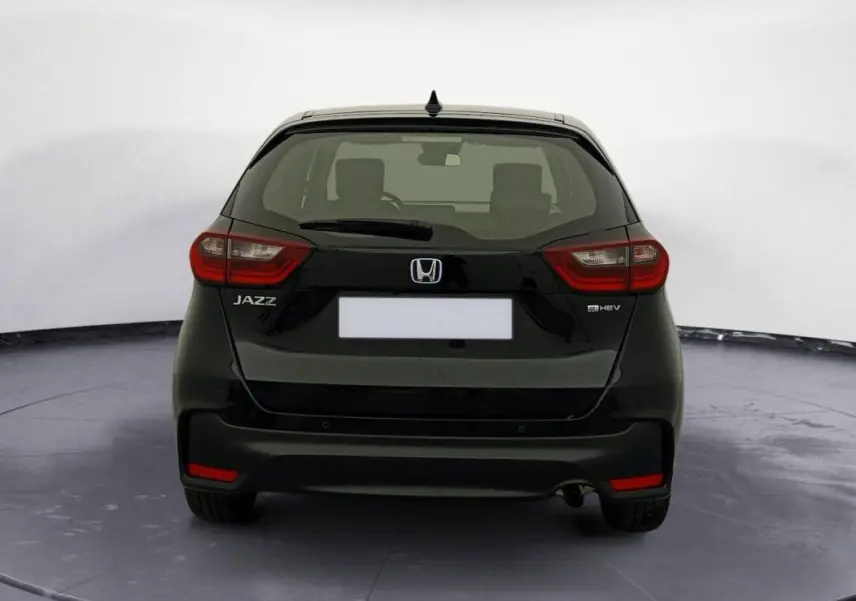 Vue arrière d'une Honda Jazz noire 2024 E:HEV 1.5 i-MMD Advance avec feux arrière rouges et logo distinctif.