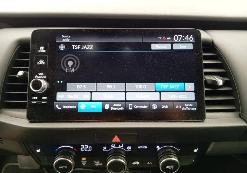 Écran tactile central de la Honda Jazz 2024 noir, affichant la radio FM TSF Jazz, avec commandes climatisation en dessous.