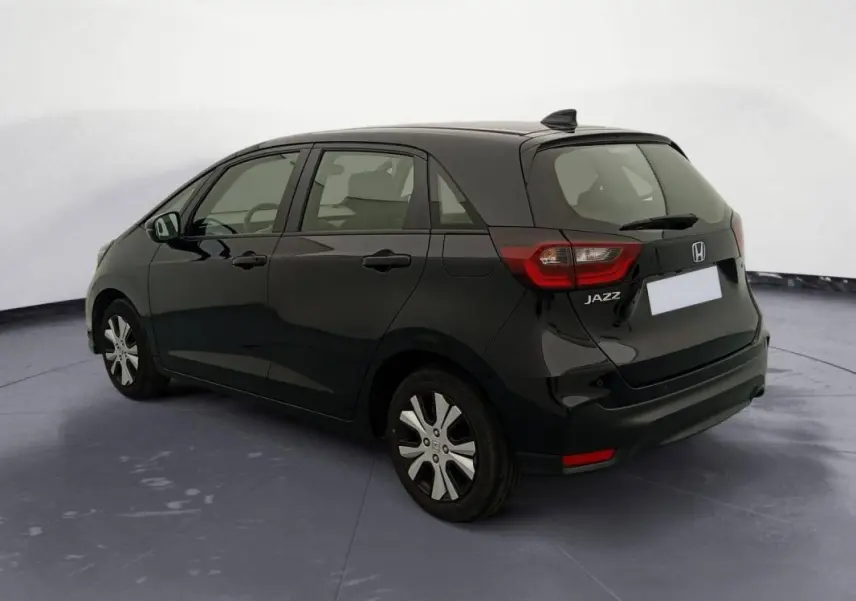 Vue 3/4 arrière droite de la Honda Jazz 2024 noire, version hybride essence E:HEV 1.5 i-MMD Advance avec jantes spécifiques.