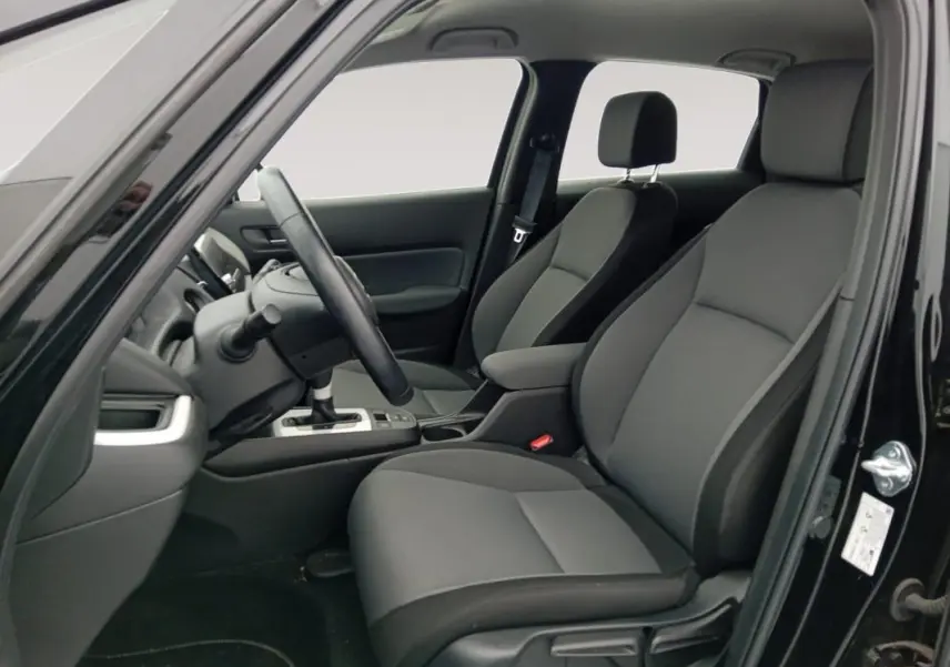 Vue intérieure côté conducteur de la Honda Jazz 2024 noire, montrant les sièges avant et le volant.