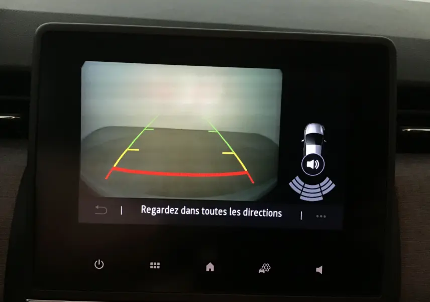 Écran de caméra de recul de la Renault Clio V gris schiste montrant les lignes d'aide au stationnement et alertes sonores.