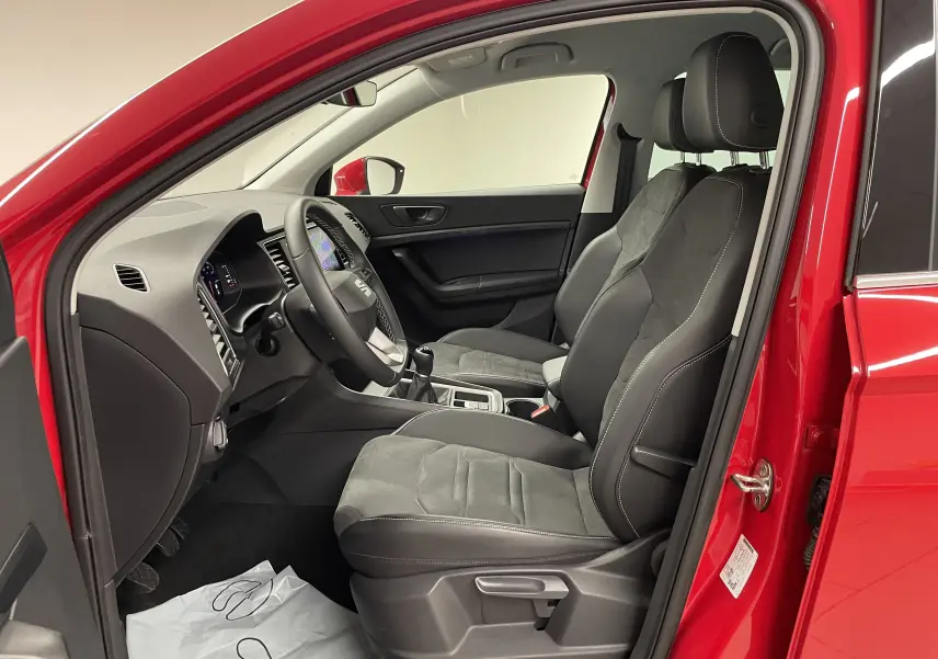 Intérieur côté conducteur du SEAT Ateca Rouge Velvet 2024, sièges en cuir et alcantara avec volant multifonction.