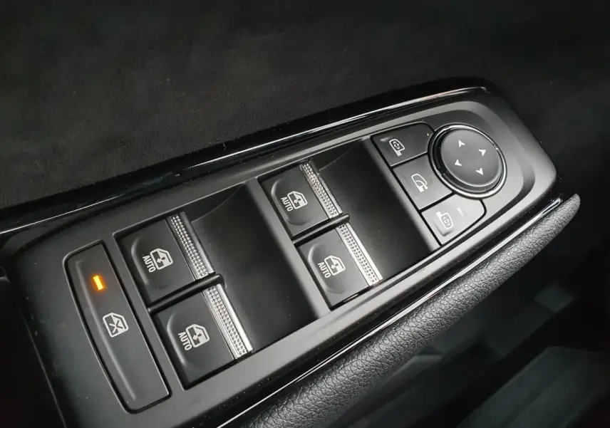 Gros plan sur les commandes de lève-vitres et rétroviseurs côté conducteur du Renault Austral gris schiste avec toit noir.