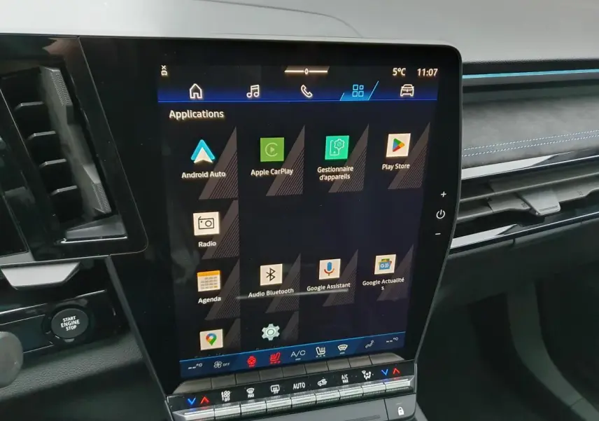 Vue intérieure centrée sur l’écran tactile vertical du tableau de bord du Renault Austral gris schiste avec finitions Alcantara.