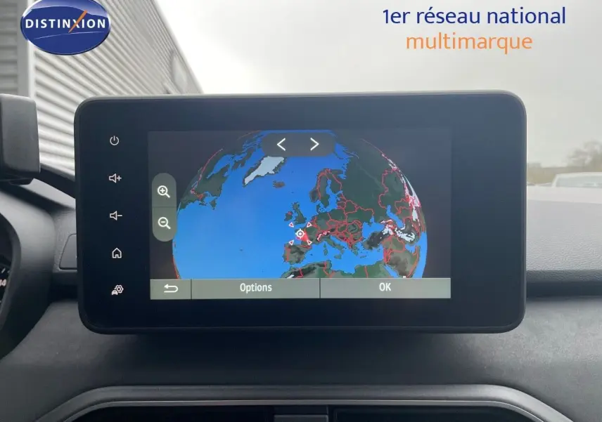 Vue intérieure centrée sur l'écran tactile du GPS affichant une carte du globe dans un Dacia Jogger gris schiste métal.