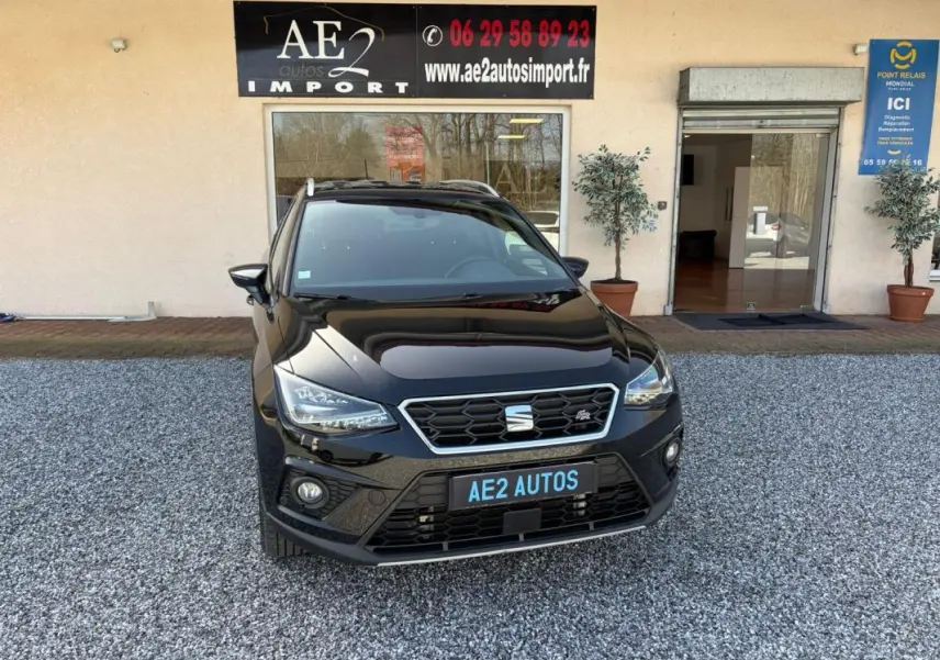 SEAT Arona noir vue de face, mettant en valeur la calandre hexagonale et les phares LED distinctifs.