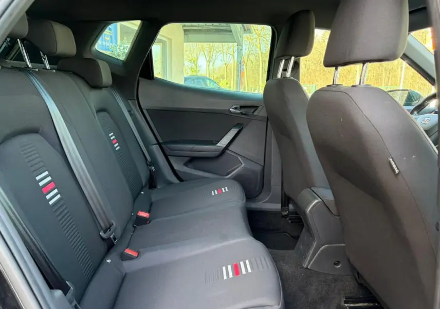 Vue intérieure côté gauche montrant la banquette arrière noire avec motifs gris et rouge du SEAT Arona 2020.