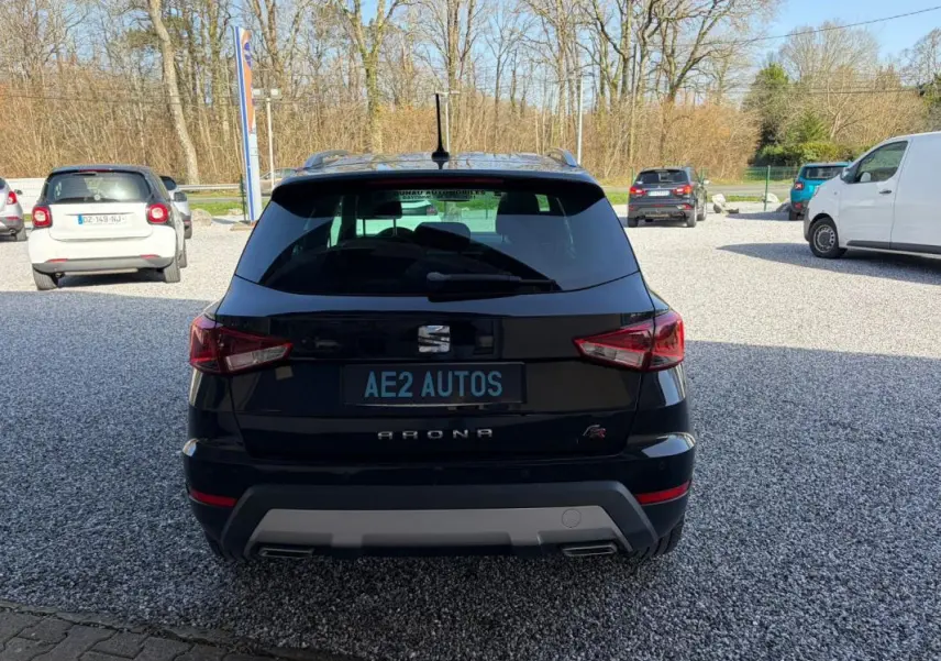 Vue arrière d'un SEAT Arona noir 2020 avec logo FR et double sortie d'échappement sur un parking extérieur.