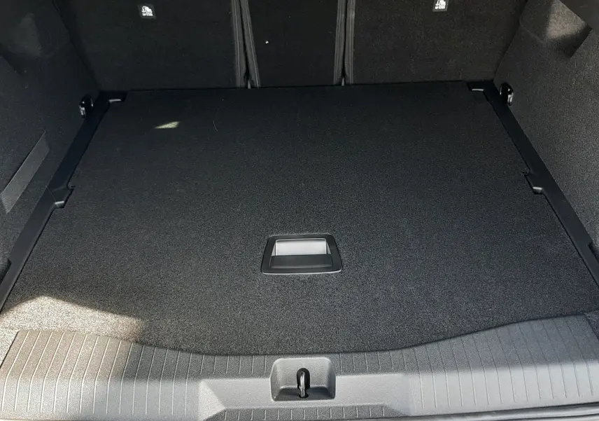 Coffre ouvert vu de l'arrière du Citroën C5 Aircross vert Astoria avec intérieur noir et plancher plat.