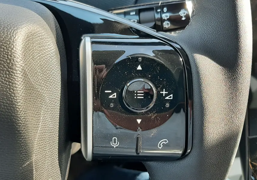 Gros plan sur les commandes noires du volant côté gauche du Citroën C5 Aircross hybride 2026, avec boutons multifonctions.