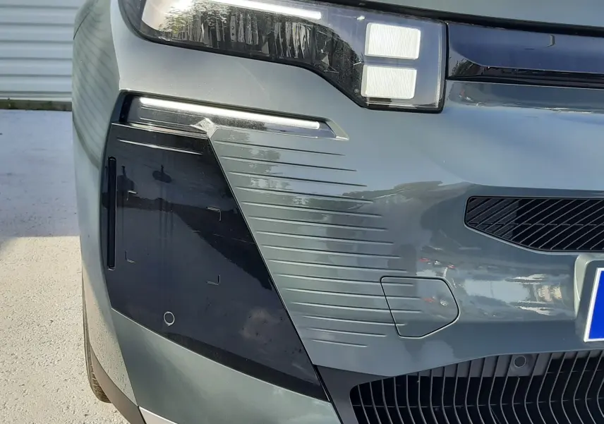 Gros plan sur l'avant gauche du Citroën C5 Aircross vert Astoria avec phares LED et détails noirs contrastants.