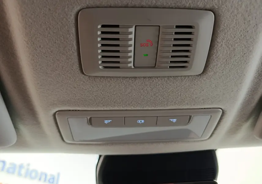 Vue intérieure du plafond beige avec bouton SOS rouge et commandes d'éclairage dans un MG ZS blanc hybride 2026.