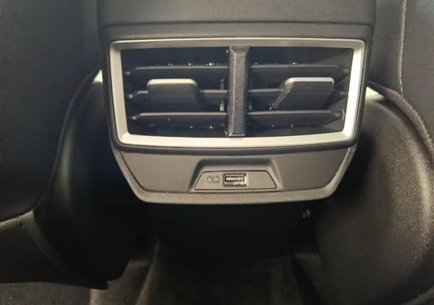 Prise USB et sortie d’air arrière encadrées de plastique noir dans l’habitacle du MG ZS blanc.