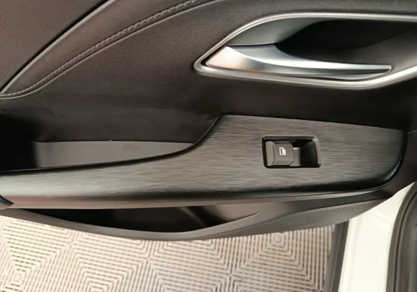 Détail de la porte côté conducteur du MG ZS blanc 2026 avec bouton de verrouillage et finition noire texturée.