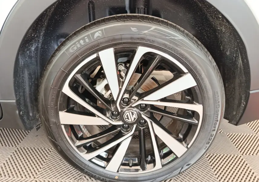 Gros plan sur la roue avant droite du MG ZS blanc, mettant en valeur la jante alliage bicolore au design moderne.