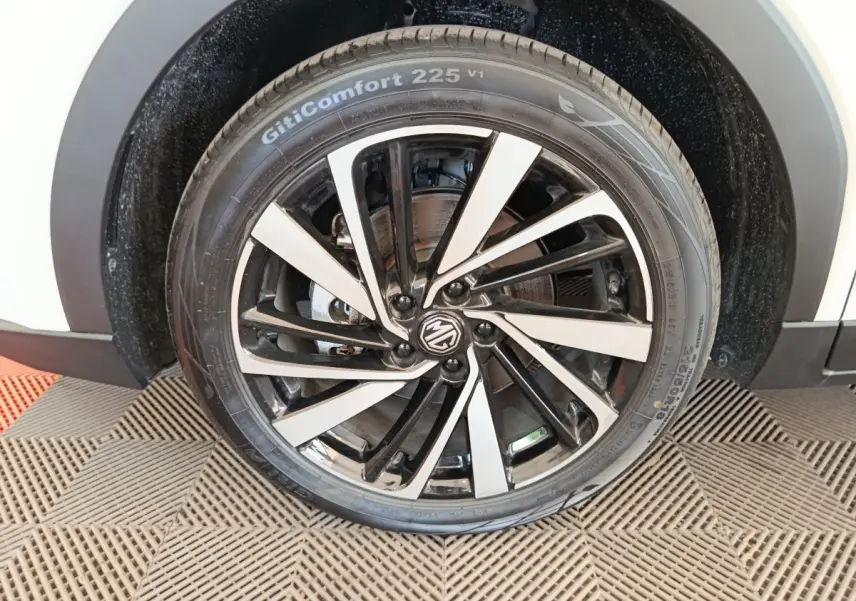 Gros plan sur la roue avant droite blanche du MG ZS 1.5L Hybrid+ Luxury avec jante noire et argentée au design dynamique.