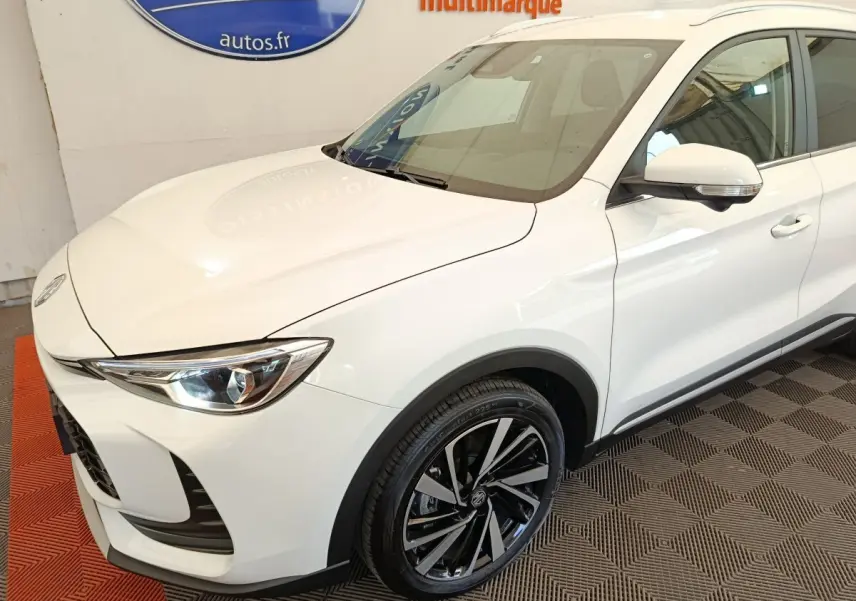 Vue 3/4 avant droit du MG ZS blanc avec jantes alliage noires et détails chromés sur rétroviseur.