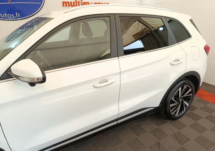Vue latérale droite du MG ZS blanc avec jantes alliage noires et détails noirs sur les bas de caisse.