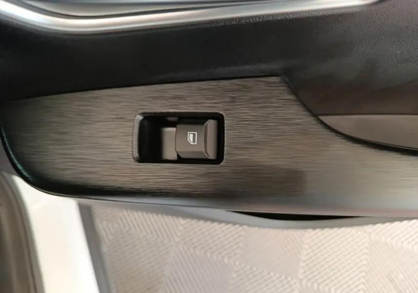 Bouton de commande de lève-vitre sur la porte intérieure côté conducteur d’un MG ZS blanc.
