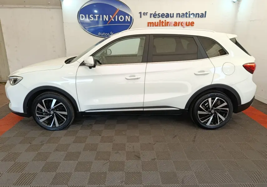 Vue de profil côté gauche d’un MG ZS blanc 2026 avec jantes noires et détails noirs sur bas de caisse.