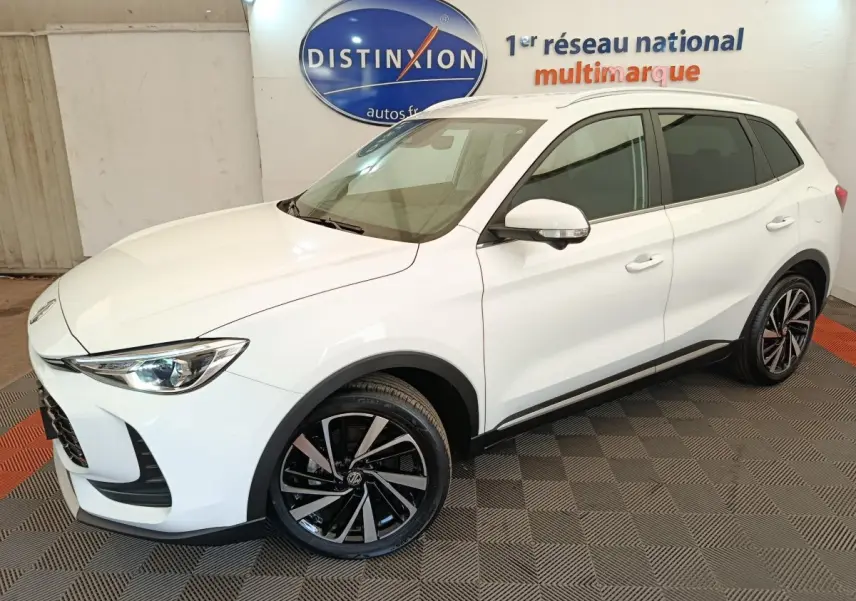 MG ZS blanc en vue 3/4 avant droit, avec jantes alliage noires et toit blanc dans un showroom intérieur.