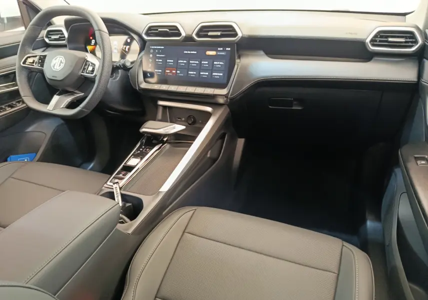 Vue intérieure côté conducteur du tableau de bord et console centrale du MG ZS Hybrid+ Luxury avec écran tactile et volant cuir noir.