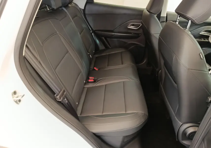 Vue côté gauche sur la banquette arrière en cuir noir du MG ZS blanc, avec accoudoirs centraux visibles.