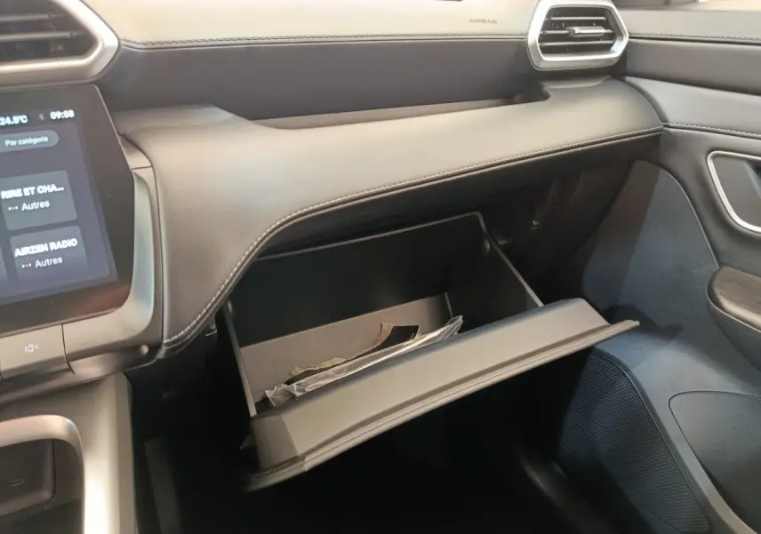 Intérieur MG ZS 1.5L Hybrid+ Luxury vu côté passager, boîte à gants ouverte avec documents visibles.