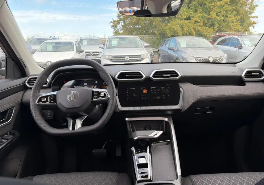 Vue intérieure frontale du tableau de bord du MG ZS 1.5 hybrid 197 en gris Camden avec volant multifonction et écran tactile central.