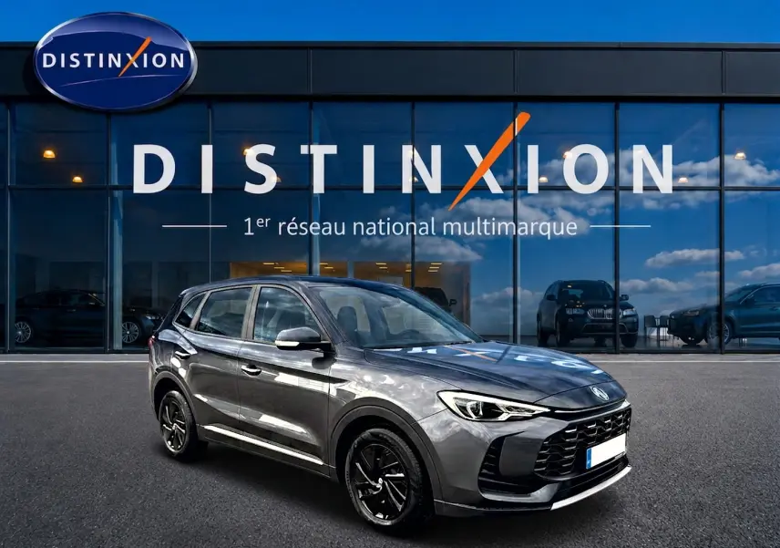 MG Motor ZS 1.5 hybrid gris Camden, vue 3/4 avant droit, avec jantes noires et calandre imposante.