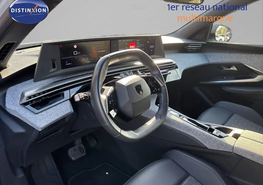 Intérieur du Peugeot 5008 2025, vue côté conducteur, tableau de bord moderne avec volant compact et finitions tissu gris.