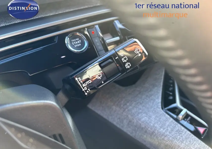 Détail intérieur du Peugeot 5008 2025 montrant la commande d’essuie-glace et le bouton start/stop sur fond de tableau de bord noir.
