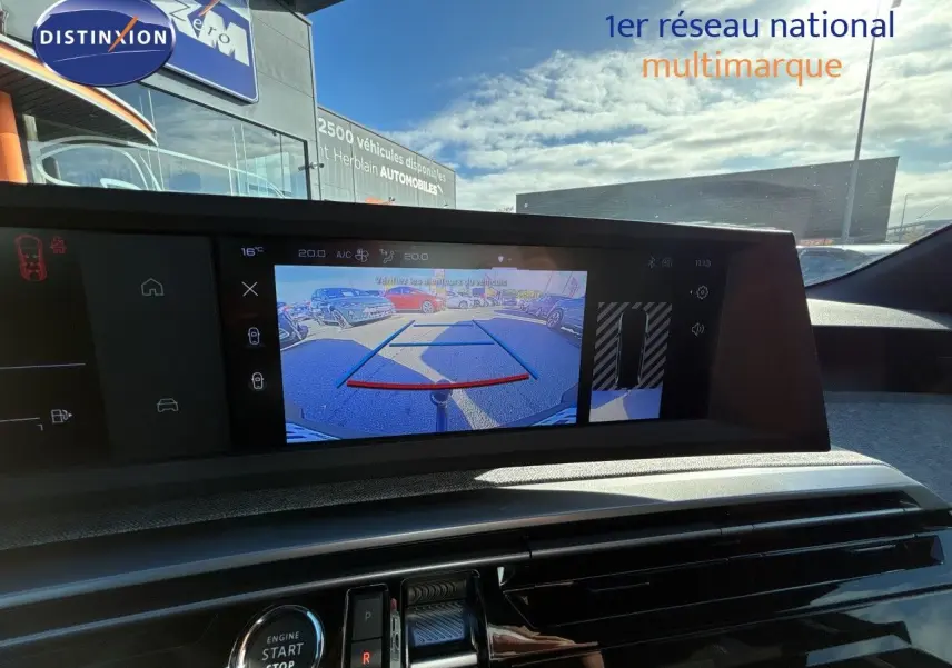Vue intérieure du tableau de bord du Peugeot 5008 blanc Okenite 2025, avec écran affichant la caméra de recul.