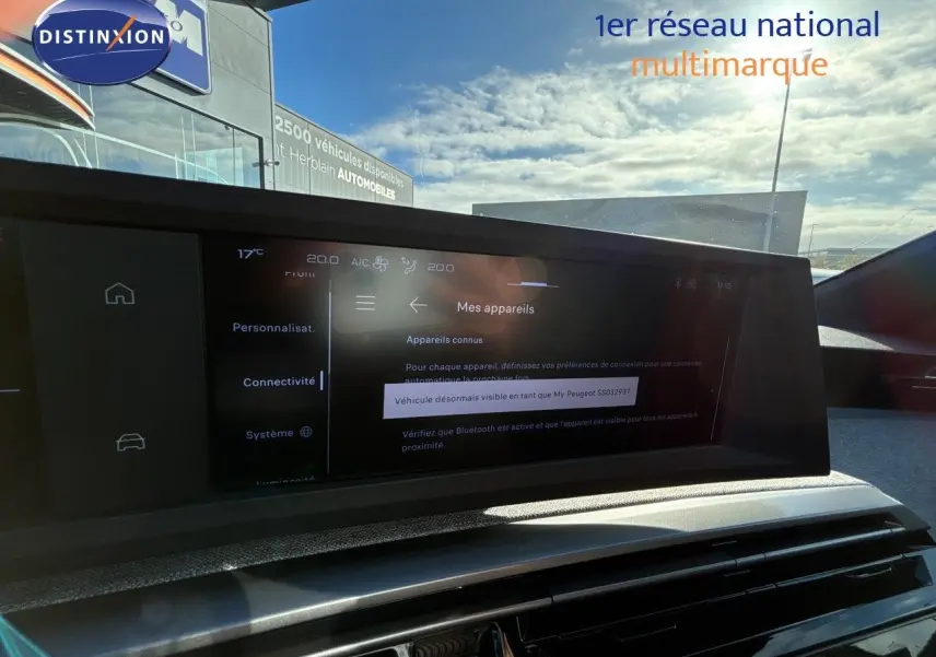 Vue intérieure du tableau de bord du Peugeot 5008 blanc Okenite, écran tactile affichant les paramètres de connectivité.