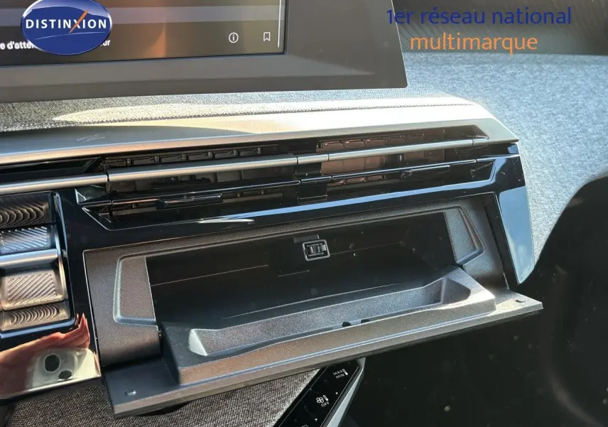 Gros plan sur la boîte à gants ouverte du Peugeot 5008 blanc Okenite, mettant en valeur la finition intérieure moderne.
