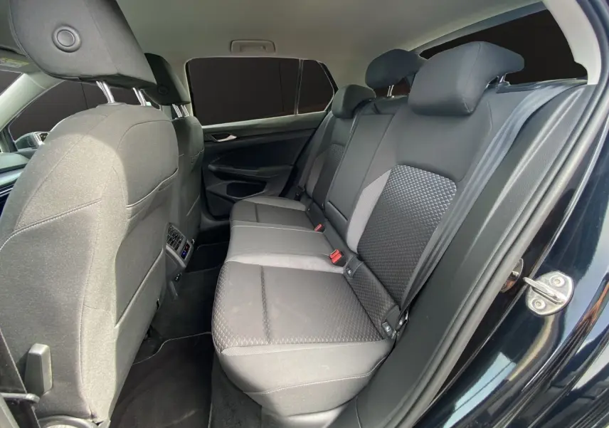 Vue intérieure côté droit sur la banquette arrière noire en tissu de la Volkswagen Golf VIII 2022 avec vitres surteintées.