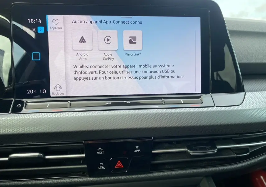 Écran tactile central du tableau de bord d'une Volkswagen Golf VIII noire, affichant les options de connectivité mobile.
