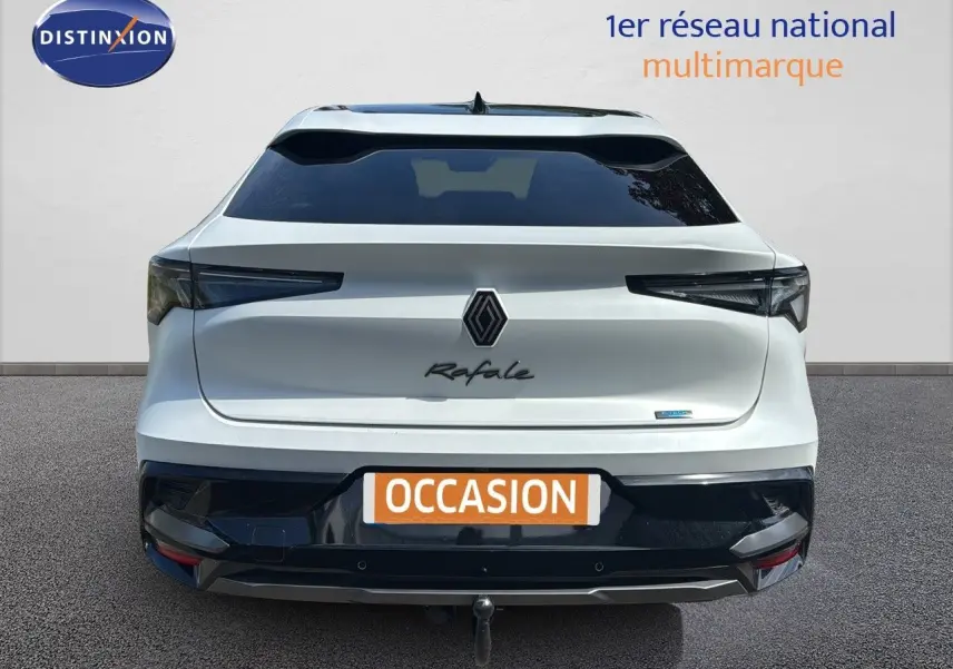 Vue arrière d'une Renault Rafale blanche satin avec toit noir et attelage visible sur fond neutre.