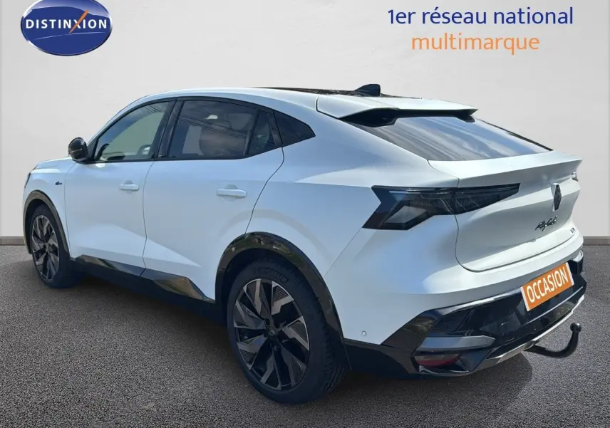 Vue 3/4 arrière droite d'une Renault Rafale 2024 blanc satin avec toit noir et attelage visible.