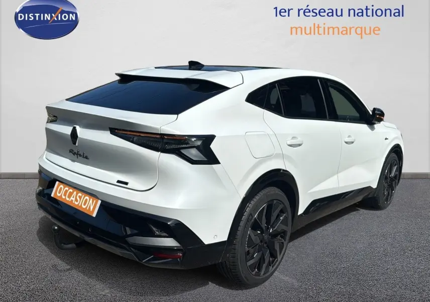 Vue 3/4 arrière droite d'une Renault Rafale 2024 blanc satin avec toit noir et attelage visible.